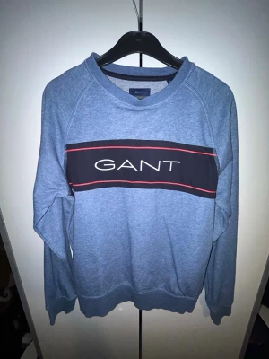 Blå sweatshirt från Gant - En stilren blå sweatshirt från Gant med rund halsringning och långa ärmar. Tröjan har ribbade muddar vid ärmslut och nederkant, perfekt för en avslappnad look. Tillverkad i mjukt bomullsmaterial för extra komfort.