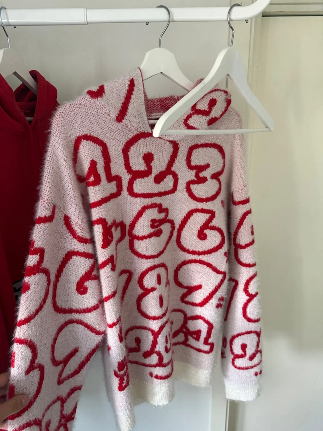 Rosa stickad tröja med röda siffror