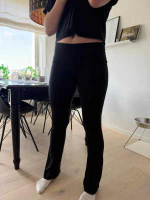 Svarta utsvängda leggings - Säljer ett par svarta leggings med utsvängda ben och låg midja. De är mjuka och stretchiga, perfekta för en avslappnad dag. Passar till crop tops eller oversized tröjor. Materialet känns lent och följsamt mot huden✨✨