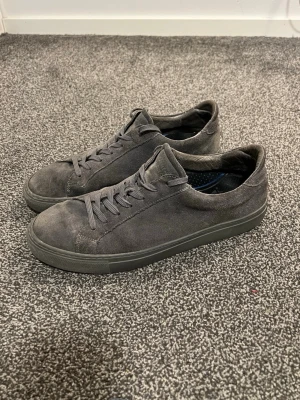 Garment Project Män Låg sneaker - Stilrena mörkgrå sneakers i mocka – 399 kr  Säljer ett par stilrena Garment Project sneakers i mjuk mocka med matchande mörkgrå snörning och sula. Klassisk låg modell med minimalistisk och clean design – perfekt för dig som gillar enkel och modern stil.  🖤 Färg: Mörkgrå 👟 Storlek: 43 📌 Heeldrag samt lite missfärgningar på mockan (se bilder) 🧦 Innersula medföljer ej – du behöver fixa ny sula själv  💡 Nypris: ca 1 800–2 000 kr för liknande modell (suede/låg sneaker från Garment Project) enligt åte