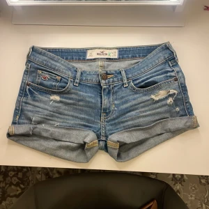 Lågmidjade jeansshorts från Hollister - Säljer ett par jätte snygga lågmidjade jeansshorts från Hollister med slitna detaljer och uppvikta benslut. Klassisk femficksmodell med knapp och dragkedja framtill. Säljer då dem är för små för mig💗💗