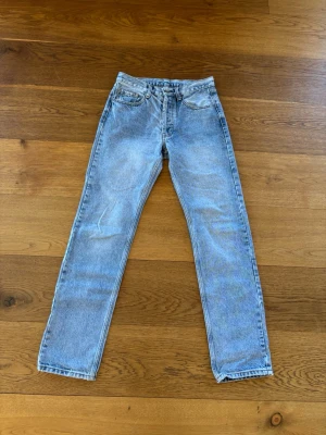 Brandy Melville Ljusblå raka jeans  - Säljer ett par ljusblå jeans med rak passform och hög midja. Klassisk femficksmodell med bälteshällor och dragkedjegylf. Jeansen har en snygg tvättad look och är tillverkade i kraftigt denimtyg, perfekta för en avslappnad stil.