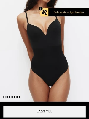 Svart shaping-body med v-ringning - Stilren svart shaping-body med djup v-ringning och tunna justerbara axelband. Bodyn har en slät och figurnära passform som ger en snygg siluett. Perfekt under tighta plagg för en smickrande look.