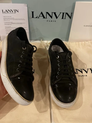 Gråa lanvins DBB1 cap toe - Grå mockaskor med cap toe från Lanvin, modell DBB1, storlek UK 6 (ungefär 40–41). Skorna är i gott skick utan större defekter, förutom lagade hälar och utbytt sula. Nypris ligger på 4499 kr, men säljs nu för 1899 kr. Tillbehör som följer med är originalbox, två dustbags och kvitto.  Kolla gärna in profilen också, där finns flera märkeskläder och skor – du hittar säkert något mer som passar 😉💯 Hör av dig om du undrar något!