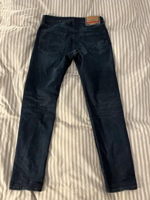 Diesel Jeans oanvända - Säljer ett par snygga Diesel jeans med snygg wash. De har endast använts ett fåtal gånger.                                                Nypris 1499kr                                                           Midja 40 cm                                                                          Längd 103 cm                                                                     Benöppning 16,5 cm                                                           Om du undrar något är det bara att fråga!