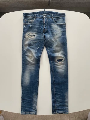 Distressed blå jeans från Dsquared2 - Rintigt snygga Dsquared2 jeans i perfekt skick i storlek 48. Jag säljer dem för att de inte är min stil längre och behöver pengarna. Priset går att diskutera vid snabb affär. Hör gärna av dig vid funderingar!