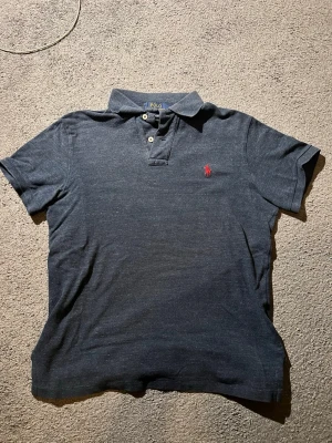 Mörkblå piké från Ralph Lauren - Säljer en i princip helt ny piké från Ralph Lauren, väldigt sparsamt använd. Storleken är S