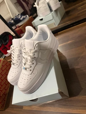 Nike Air Force 1 x NOCTA vita sneakers - Säljer ett par fräscha Nike Air Force 1 x NOCTA sneakers i helvitt läder. Klassisk låg modell med perforerad tå, vita skosnören och diskret NOCTA-detalj på plösen och innersulan. Perfekta för dig som gillar stilrena och tidlösa sneakers.