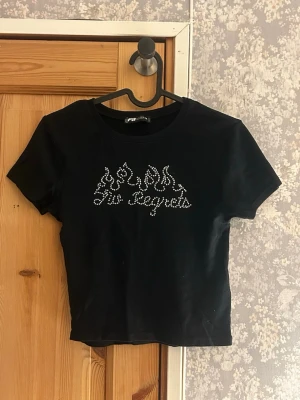 Svart croppad topp med strasstext - Svart croppad topp från New Yorker. Bra skick. Hör av vid frågor!💗