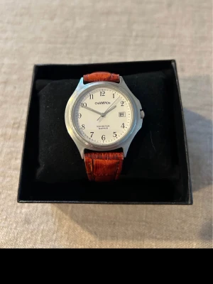 1980 Champion Saphir 100M 38mm Vintage - Säljer en riktigt snygg vintage herrklocka från Champion i absolut nyskick. Troligtvis från sent 80-tal. Ser oanvänd ut. Fungerar utmärkt med nytt batteri, vackert rödbrunt armband i läder, datumvisare, vattentät osv.  Nypris: 1200 SEK Begagnat pris: 600 SEK Mitt pris: 249 SEK  Skickas spårbart samma dag mot förskottsbetalning eller hämtas i Glumslöv.  Hör av dig vid frågor och se gärna mina andra annonser också!   /Jakob