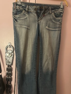 Blå bootcut jeans med broderade fickor - Säljer ett par blå bootcut jeans från Miss ViVi med snygg slitning framtill och broderade bakfickor med paljettdetaljer 💓Jeansen har låg midja, klassisk femficksdesign och är tillverkade i denim med stretch för extra komfort 💓 Jag är 162 💓