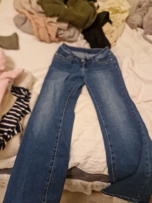 Blå jeans med fjärilsbrodyr från madlady - Säljer ett par blå jeans med raka ben och snygga fjärilsbroderier på bakfickorna. Jeansen har klassisk femficksmodell och knappgylf. Perfekta för dig som vill ha något unikt i garderoben! Från madlady i storlek s till m kort av klippt lapp