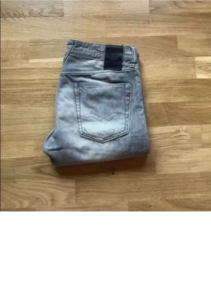 Replay jeans  - Säljer ett par ljusgrå jeans från Levi's med raka ben och klassisk femficksmodell. Jeansen har slitna detaljer och en snygg tvätt som ger en avslappnad look. Perfekta för dig som gillar en casual stil.