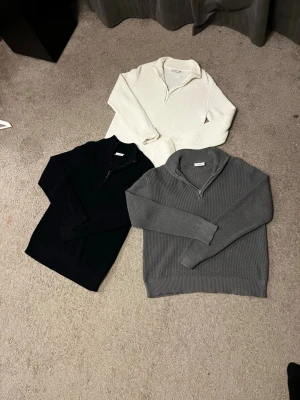 stickad halvzip tröja - Snygg stickad tröja med halvzip och ribbad struktur. Tröjan har lång ärm och hög krage som kan bäras både uppvikt och nedvikt. Perfekt för att matcha med olika outfits. Blå L/grå XL 250kr vit L 175kr