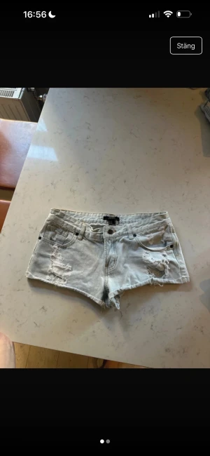  slitna jeansshorts - Säljer ett par jeansshorts med slitna detaljer. Storlek 27.