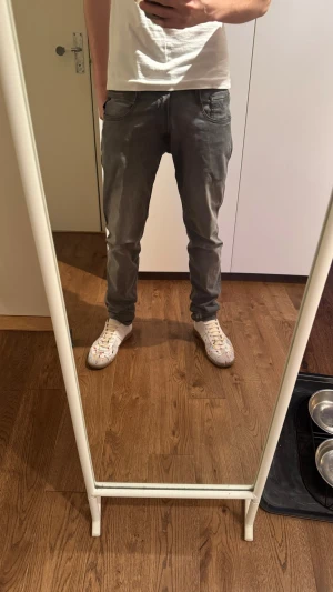 Gråa Anbass slim fit jeans - Säljer ett par gråa slim fit jeans med klassisk femficksdesign och normal midja. Jeansen har en snygg tvättad look och raka ben. Perfekta för dig som gillar en enkel men stilren stil.