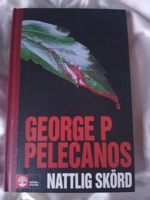Nattlig skörd av George P Pelecanos - En spännande roman med hård pärm, svart framsida och röd rygg. Perfekt för dig som gillar kriminalromaner och thrillers. Köpt från ett bibliotek men ändå bra skick.