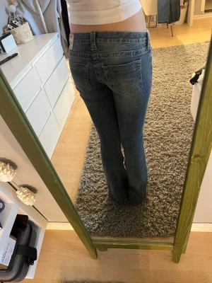 Blå bootcut jeans  - Säljer ett par jeans från true religion i storlek 27. Dom är använda en gång och är i bra skick. Midjemåttet är 38cm och innerbenslängden är 81cm. Skriv om du undrar något💕