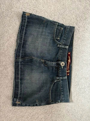 Jeanskjol - En blå lowwaist jeanskjol. Lite fina detaljer på fickorna!