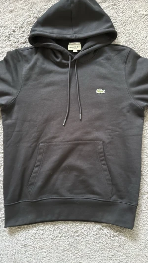 Lacoste hoodie ( prisförslag ) - Säljer en LACOSTE hoodie den är ny så det finns absolut inga defekter eller missfärgningar 🙌 ny pris på denna sällsynta hoodie är 1699kr och jag säljer den för 1199kr här väldigt bra pris enligt mig om ni inte tycker de så kan vi diskutera om priset men då ska de vara en smidig och snabb affär utan krångligheter🤝