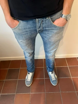 Dondup jeans  - Riktigt snygga ljusblå jeans med slitningar från dondup. Nypris cirka 3000 - mitt pris 749 men det går att diskutera. Modellen är 180 cm och väger cirka 65 kg. Hör av dig vid minsta fundering! 