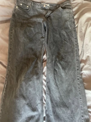 Gråa utsvängda jeans från NA-KD - Säljer ett par gråa jeans från NA-KD i modell med utsvängda ben. Då dom tyvärr blivit för stora 