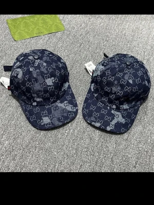 Gucci denimkeps med GG-mönster - Säljer en snygg keps från Gucci i mörkblå denim med det klassiska GG-monogrammet över hela kepsen. Kepsen har böjd skärm, justerbar rem bak och cool patchwork-effekt i tyget. Perfekt accessoar för att lyfta din streetwear-look.