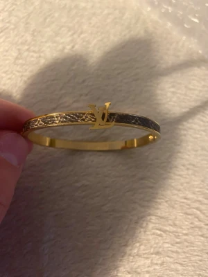 Guldig armband från H&M - H&M. Lite defekterat där man ska stänga plus Där L står.
