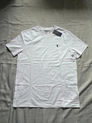 Ralph lauren T-shirt vit strl L - Helt ny Ralph Lauren T-shirt i vit färg säljes. Stilrent och enkelt basplagg med klassisk passform. Perfekt till vardag och sommar. Oanvänd i storlek L snabb frakt 