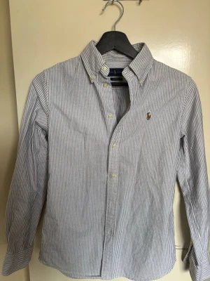 Ralph Lauren Randig Skjorta  - Säljer denna feta skjortan då den är för liten för mig. Den är i extremt fint skick utan tecken på användning! Storleken är xs och passformen är custom fit. Jag svarar gärna på frågor om produkten!