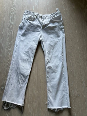 Vita raka jeans från Zara - Säljer ett par vita jeans med rak passform som är kortare. 