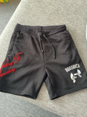 Svarta shorts från Hoodrich med tryck - Storlek S, använd 2-3 gånger, bra skick