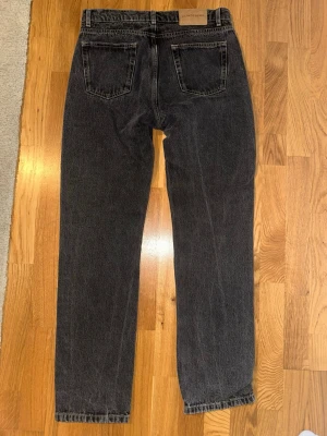 Svarta raka jeans från J.Lindeberg - Snygga svarta jeans från J.Lindeberg i rak modell. Jeansen har klassisk femficksdesign och är tillverkade i kraftig denim med kontrastsömmar. Perfekta för en stilren och avslappnad look.