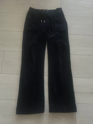 Marinblå Juicy couture byxor  - Säljer ett par marinblå Juicy couture byxor . Byxorna har fickor fram och bak med knappdetaljer bak. Jag är 160 och dom passar mig men jag använder dem inte. Byxorna är sparsamt använda. 💙