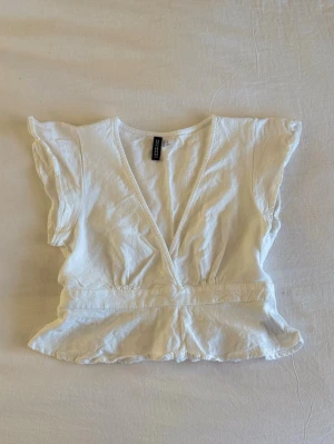 Vit topp - Supersöt v-ringad topp i linne med band, går att knyta både fram och bak. Endast använd två gånger