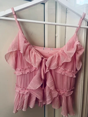 Rosa volang topp med knyt - Busfläckar vid armhålorna