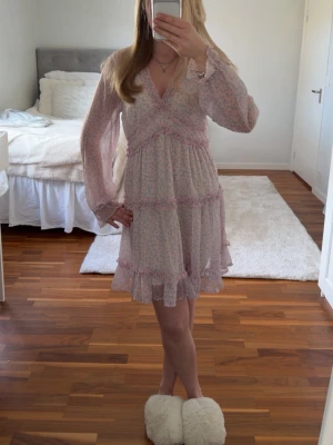 Kort blommig klänning  - Säljer en kort söt blommig klänning från vero Moda i storlek M. Bara använd två gånger och säljer då den eftersom klänningen inte kommer till användning.