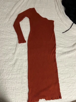 Rostbrun ribbad långklänning NA-KD - Säljer en lång, ribbad klänning från NA-KD i en snygg rostbrun färg. Klänningen har lång ärm och är figurnära med stretchigt material. Perfekt för dig som gillar stilrena och trendiga plagg.