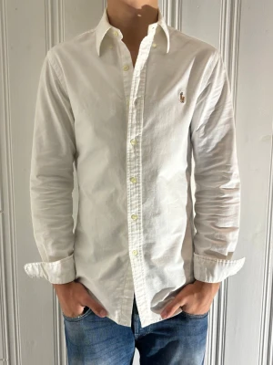 Vit Ralph Lauren skjorta - Säljer min vita Ralph Lauren skjorta som är i toppen skick skjortan är använd ungefär vid 5-6 tillfällen och har nästan inga tecken på användning. nypris ca 1600kr skjortan nu inför våren och sommaren Det är bara att höra av dig om du har några frågor eller funderingar