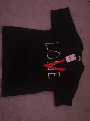 Svart VLONE t-shirt med LOVE-tryck - VLONE tröja, köpte medium men den passar bättre på large så därför säljer jag den. 