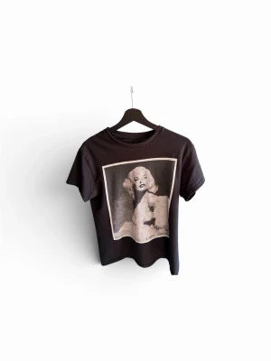 Svart t-shirt med grafiskt tryck - Cool svart t-shirt med ett stort grafiskt tryck på framsidan av marly ma rose. T-shirten har rund hals och korta ärmar, perfekt för dig som gillar streetstyle och konstnärliga motiv. Materialet är mjukt och känns skönt mot huden, troligtvis bomull. Den går inte att köpa längre därav priset!🙌🏼 perfekt nu till sommaren.