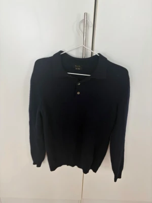 Mörkblå cashmere-tröja med krage - Snygg mörkblå tröja från Massimo dutti i mjuk cashmere. Tröjan har klassisk krage och tre knappar framtill, samt långa ärmar och ribbade muddar. Perfekt för dig som gillar stilrena och exklusiva plagg.