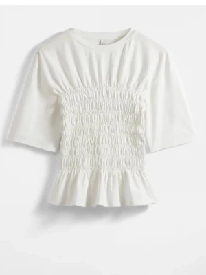 Vit smockad topp med volangkant - Trendig vit topp med smockad midja och volangkant nedtill. Toppen har korta ärmar och en figurnära passform som framhäver midjan💕heeelt oanvänd etikett och prislapp kvar :)