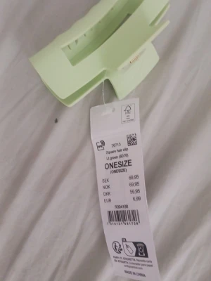 Ljusgrön hårklämma onesize - Säljer en stilren ljusgrön hårklämma i fyrkantig form. Perfekt för att snabbt sätta upp håret med en trendig touch. Tillverkad i plast och passar alla hårtyper. Enkel att matcha med olika outfits. Kostade 70kr i affär