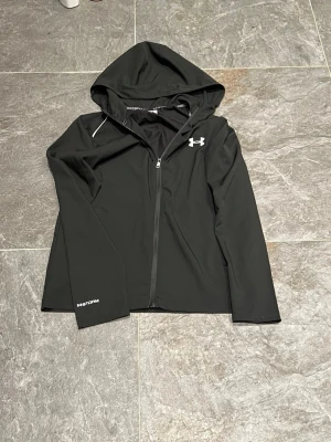 Under Armour Vindjacka - Hej! Säljer nu min riktigt snygga Under Armour Vind jacka. Super fin jacka som passar alla möjliga outfits. Säljs då den inte kommer till användning. Hör av er privat vid minsta lilla fundering!