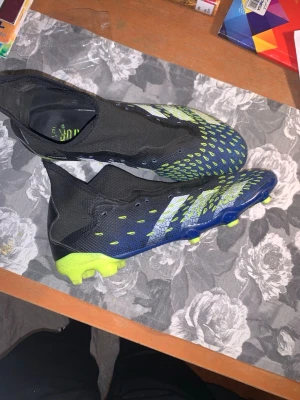 Adidas Predator Freak+ fotbollsskor - Säljer ett par Adidas Predator Freak+ fotbollsskor i svart, blått och neongult. De är använda i mellan bra-okej skick