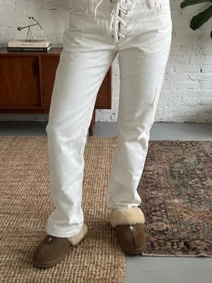 Slutsålda Virala Zara Byxor - Säljer dessa otroligt snygga och unika byxor från Zara! De är helt slutsålda online och i butik. Byxorna är i en fräsch krämvit/off-white färg och har en trendig snörningsdetalj i midjan. Modellen är vida ben (wide leg) vilket ger en jättefin siluett och är superbekväma🤍 