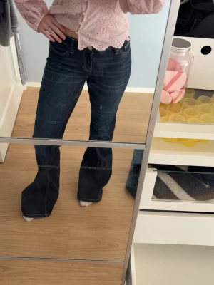 Mörkblå flare jeans med låg midja - Säljer ett par mörkblåa flare jeans med låg midja och vita kontrastsömmar. Jeansen är i mycket bra skick och knappt använda💓