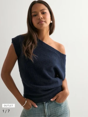 Oneshoulder topp - Snygg mörkblå oneshoulder topp från Nelly i mjukt stickat material. Toppen har en avslappnad passform och är perfekt för dig som vill ha en trendig och bekväm look. Passar till både jeans och kjol för en cool stil.
