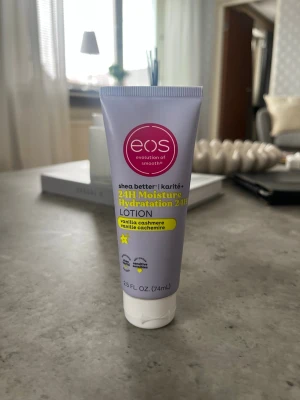 EOS 24H Moisture Lotion Vanilla Cashmere - En smidig hand- och kroppslotion från EOS med doft av Vanilla Cashmere. Tuben är ljuslila med vita och gula detaljer och innehåller 74 ml. Innehåller sheasmör för långvarig återfuktning och har en mjukgörande formula.